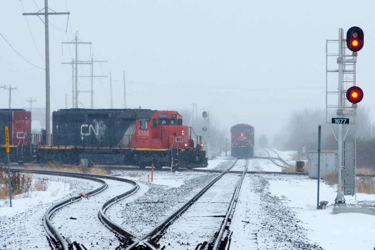 When the weather outside is frightful... the trains run like streetcars!  CN 5386 pounds the diamond at East Edmonton while an empty CP crude train waits to pull across, then back into the Kinder Morgan terminal at left.
