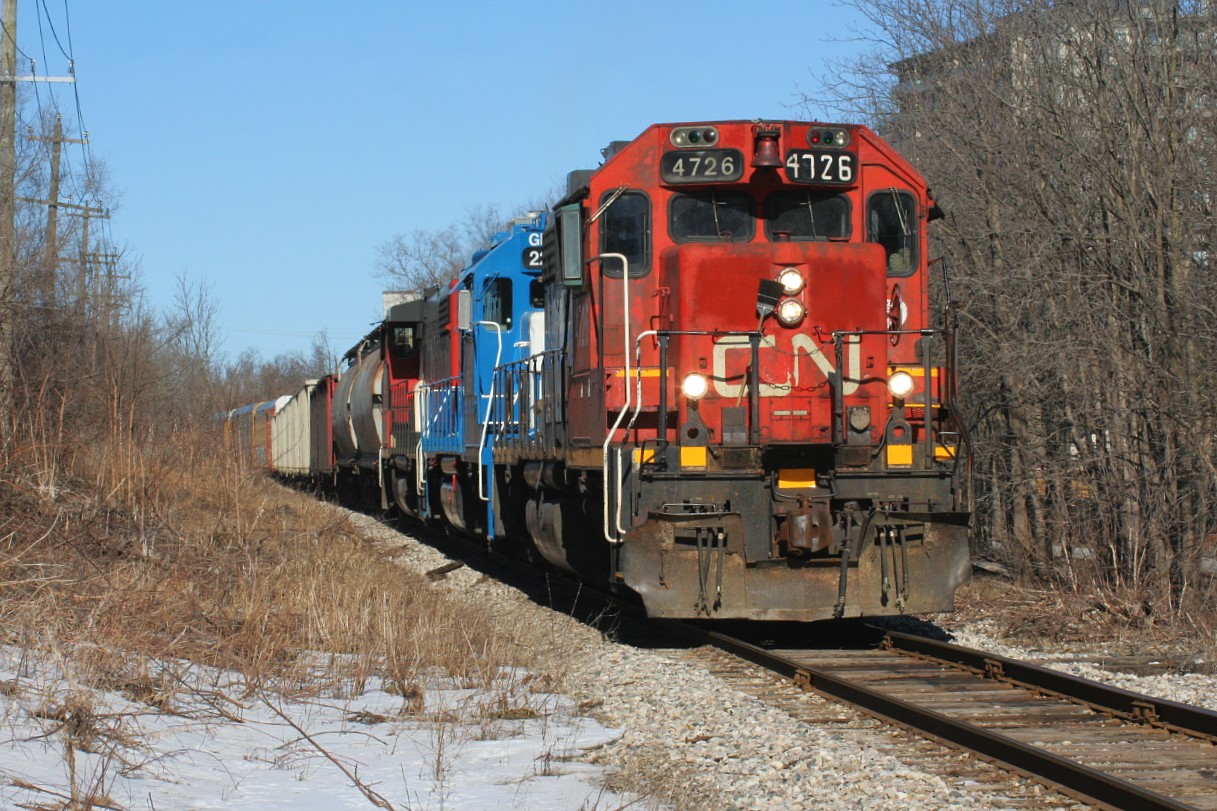 CN L540 is approaching Mill Street in Kitchener on the Huron Park Spur in early morning light. Powering the train are 4726, GMTX 2255 and 4761. GP38-2 4726, with its unique number-board, was set-off by the previous night’s A431. L540 would set-off all its cars at the interchange with Canadian Pacific and return light power back to the Kitchener yard. As a side note, to the very right is the Iron Horse Trans Canada Trail, which was once a section of CP's Waterloo Subdivision and saw it's last train in July 1993.