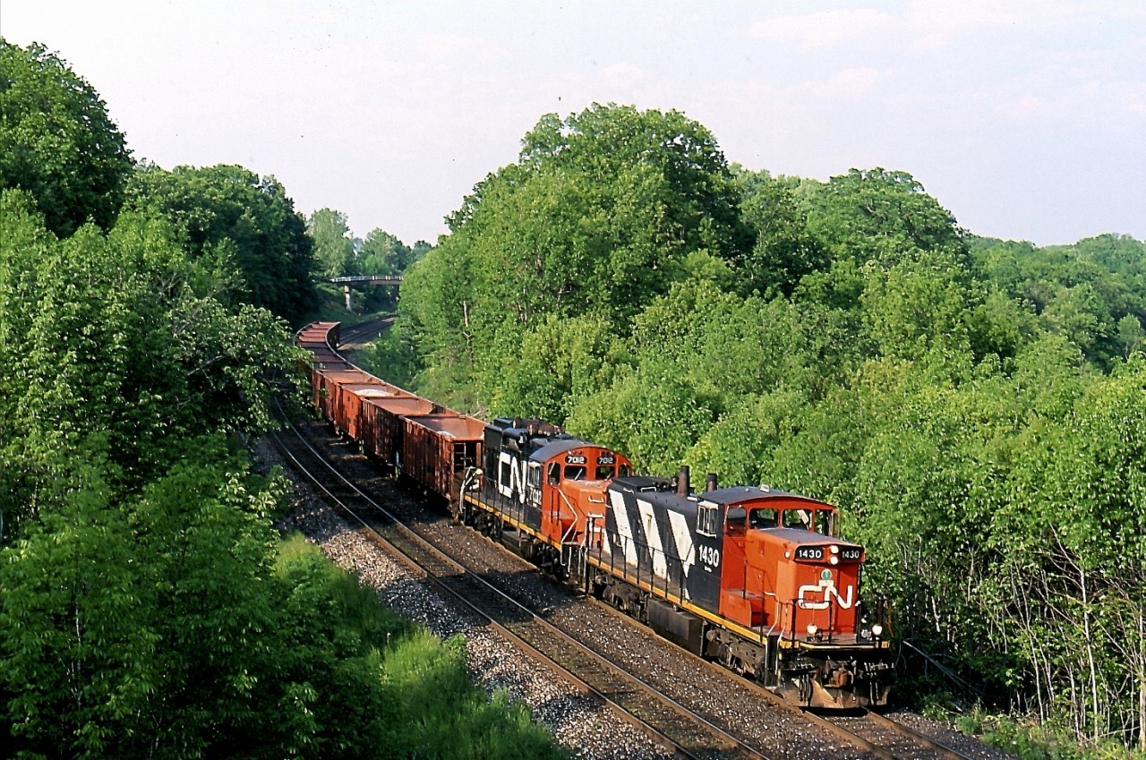 The shadows are beginning to grow long thus late spring day as a CN ballast train led by GMD1 1430 rolls into Bayview junction. The train will soon use the wye so it can face the opposite direction in order the drop ballast on the north track as they head for Aldershot.
