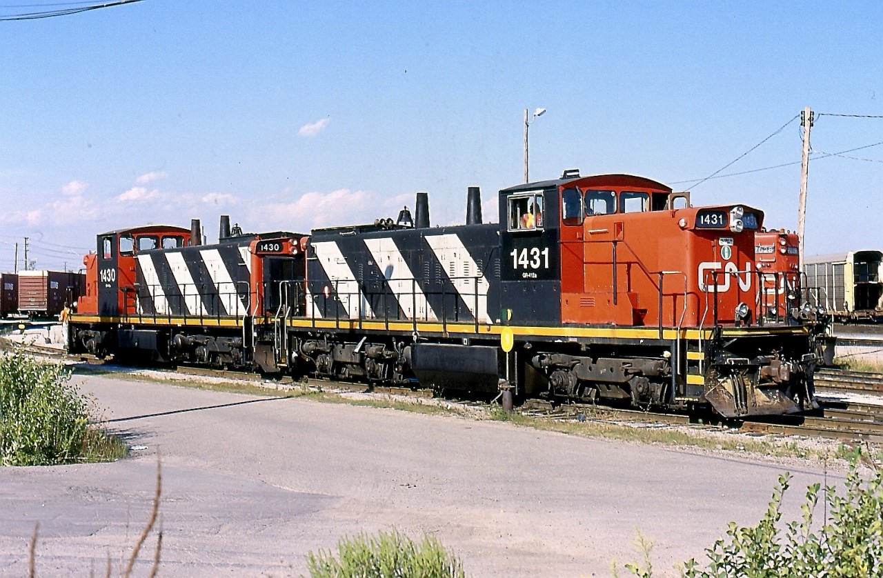 In the early 2000's the GMD1'S were still pretty rare in eastern Canada. Not long before I took this photo GMD1'S 1430 & 1431 arrived in Toronto. The pair had previously been assigned to the prairies and their light weight branchlines. The fresh paint and number on 1431 is due to its recent renumbering from 1601, at the same time it lost its distinctive six axle A-1-A trucks. 1430 was previously 1600. This pair spent decades serving the network if prairie branchlines and sadly helped disassemble many of the same line just prior to heading east. The pair is seen in Oakville yard preparing a transfer job that will next head to Aldershot yard. Unfortunately the pair was retired a number of years ago but luckily a free other GMD1's have since taken their place, although their numbers are shrinking fast.