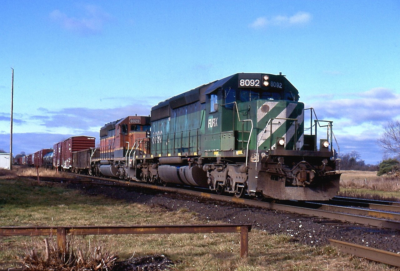 The Hunter Harrison years are not fondly remembered by most railroaders, but for railfans it meant just about anything could show up on trains as his "Precision Railroading" basically meant get the trains over the road as quickly as possible with whatever power was available, even if it meant bending the rules a lot. Case in point this day was train 394 with a First Union ex BN SD40 on the point with no Canadian approved appliances in the cab. It wasn't long before the union stepped in but there were still the occasional exception that slipped through. This day train 394 rolling through the small town of Lynden. The old abandoned junction to the "Brantford bypass" is in the distance beyond the curve. It once ran straight from here to Paris with another junction at Harrisburg for the line north to Galt. Today this is all abandoned although when I took this shot a stub track still remained at the junction for car storage.  The abandoned station grounds too are in the foreground and a weed covered track here once served to co-op.