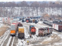 You might recognize a couple of these units as the recent faces of <a href="http://www.railpictures.ca/?attachment_id=40300" target="_blank">570</a> and <a href="http://www.railpictures.ca/?attachment_id=40367" target="_blank">555</a>. Well on this day, they were taken off 570 and were running as X421, and they’re pictured here in Hamilton making a lift. In this shot they’re tying onto a few gons and then they will shove further back to pick up those tanks three tracks to the right of the further yard set. The train they brought from Aldershot is pictured at left – with 42 wells, a few racks, and a big string of empty parts cars from Oakville. This proved to be too much for those two old barns, and I watched them from the foot bridge by the candy factory as they struggled to gain any momentum as they departed Hamilton. It took what felt like ages for them to make the roughly 8/10 of a mile trip from the yard to where I was by that point. They were some 312 axles over the detector at 42, and evidently this was a battle. They ended up stalling further east on the Grimsby Sub, with 2411 having trouble loading. The word is they then tried to isolate 4625, and it also ended up dying. With all of the C40-8Ms going into storage, one has to wonder if it was the last revenue run for these two. Funnily enough, I heard the yard crews ask the crew of X421 where they got that power from, and the response was "they must have found it in a museum somewhere."<br><br>531, which was in Port Rob building its train for interchange in Fort Erie and Buffalo, was called to rescue the stalled X421. With 531 spending a good chunk of their night dragging a dead X421 into Port Rob, it wasn’t able to get out on its usual transfer run. This resulted in quite the domino effect: 1) 539 did the usual duties of 531. 2) An X539 was called at 0200 to do usual 539 duties, and it outlawed at CN Duff on the return from Buffalo when it runs as 538. 3) The trainmaster then drove the crew 562 from Port Rob down to Fort Erie to relieve the crew of 538, so 562 wasn’t able to do its usual duties that day (such as build that day’s 531). 4) With 538 being so late, 422 wasn’t out until very late in the afternoon (dragging the dead 4625 and 2411 along with it), and 5) without 562 to build 531, poor 531 was hours behind schedule too.<br><br>For note keeping purposes, the string of cars with the COER gon, the TBOX, and further winding around to some new NSC hoppers and scrap loads, is 555’s lift for later that night to take back to Aldershot for the next day’s 570 to Mac. The current power for 570/555 is now 8830, 2166 and 2254.