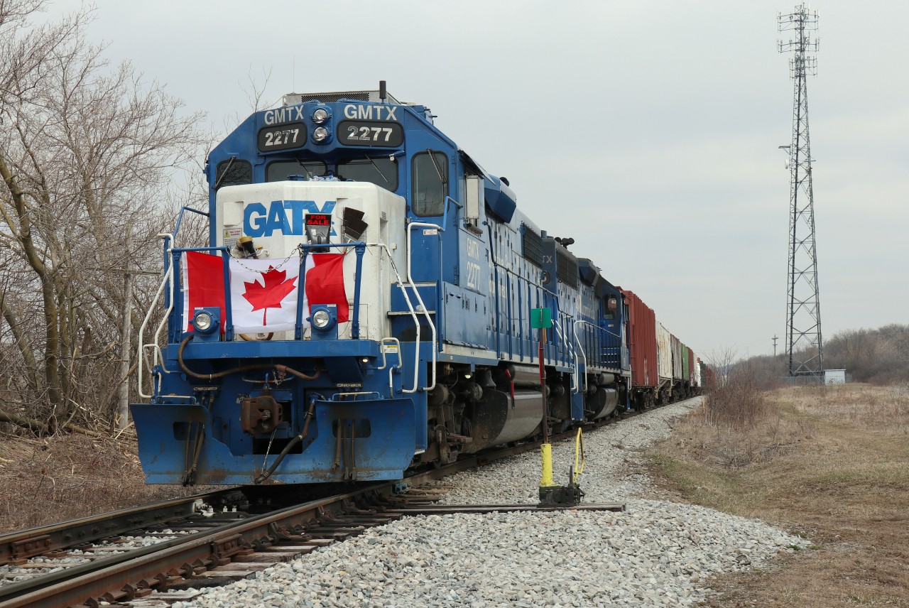 L580 is holding at switch HD 41 (base plate 36E) to allow Brush Cutter CN 69115 access to switch/siding HD 33-35.  Rail CAT 325F had to make a hasty retreat from the south for repairs after blowing a hydraulic hose. Taken within sight of home while respecting safe distancing and minutes before the sun popped out.

This photo is submitted in recognition of the patriotic crew of L580 for displaying the Canadian Flag on the lead unit (both directions) as a timely tribute to the essential workers and those helping to keep our communities and country going during this pandemic.  Our heartfelt thanks to all those who are working directly with the public during this time of crisis – your efforts and courage are truly appreciated!
