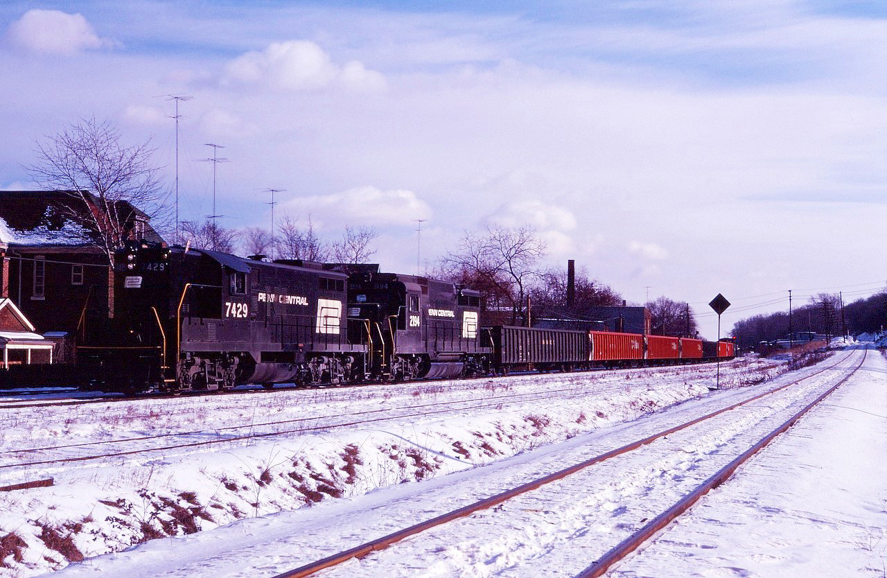While not 100 % certain, it looks like we have a Canadian Pacific train operating on the Toronto, Hamilton & Buffalo Welland sub in the Hamilton Terminal using Penn Central power. (Got that?) This train, shown approaching the CN "diamond", could be a late "Kinnear" from Buffalo or an "extra Ham" using PC GP9 7429 and GP30 2194 (laying over in Toronto). The descending track on the right is the CN Hagersville sub and the track in the middle is the CN-TH&B interchange track.