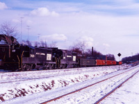 While not 100 % certain, it looks like we have a Canadian Pacific train operating on the Toronto, Hamilton & Buffalo Welland sub in the Hamilton Terminal using Penn Central power. (Got that?) This train, shown approaching the CN "diamond", could be a late "Kinnear" from Buffalo or an "extra Ham" using PC GP9 7429 and GP30 2194 (laying over in Toronto). The descending track on the right is the CN Hagersville sub and the track in the middle is the CN-TH&B interchange track.