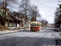 In this cold winter morning scene, TTC PCC 4098 (an A1 class car built new by CC&F in 1938) heads westbound on the Carlton route passing through east end Toronto (the Upper Beaches area), travelling westbound on Gerrard Street East passing Bellhaven Road to the west of Woodbine.<br><br>Four years earlier, car 4098 was involved in an incident with sister car 4052 when it rear-ended 4098 at Queen & Alton, damaging both cars and putting them out of service. As per TTC's Coupler employee magazine, 4052's front end was damaged beyond repair, so its intact rear end was cut off by Hillcrest Shops and welded onto the rear of 4098 to replace its wrecked end, and 4098 was put back into service. 4052 was stripped of usable parts and scrapped. 4098 lasted a few more years until the Bloor-Danforth subway opened and <a href=http://www.railpictures.ca/?attachment_id=39755><b>rendered a lot of the TTC's older PCC streetcars surplus</b></a>. As this was taken a few days prior to the B-D subway opening on the 25th, it's possible 4098 was running out its last days in service.<br><br><i>John F. Bromley photo, Dan Dell'Unto collection slide.</i>