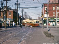 People go about their day on a Winter afternoon as TTC PCC 4399 (the last of the A6-class of PCC's, 4300-4399, built by CC&F in 1947-48) sneaks through the intersection on a yellow, turning eastbound off McCaul Street onto Dundas Street West while operating on the Harbord route on the trip from St. Clarens Loop (Davenport near Lansdowne) to Lipton Loop in the city's east end (Pape near Danforth). The zig-zagging Harbord streetcar route would be nixed in a few years when the Bloor-Danforth subway opened in February 1966, but 4399 would go on to serve nearly three more decades prowling Toronto streets, becoming the last A6 car in service when it was retired in 1990. <br><br> McCaul, an often overlooked street, still has streetcar tracks today that connect College-Dundas-Queen, as well as McCaul Loop (north of Queen) used for short turning 502 Downtowner (former Kingston Road) streetcars. At the time of this photo, S&M Super Market occupied the NW corner, Fox-Taylor Pharmacy the NE corner, and a Toronto Dominion Bank on the SW corner (that was demolished at some point in the 70's for an extension of the Art Gallery of Ontario). <br><br> <i>John Freyseng photo, Dan Dell'Unto collection (this one was a badly cyan-shifted EATONS processed Ektachrome(?) slide, with quite a bit of colour adjustment and editing performed).</i>
