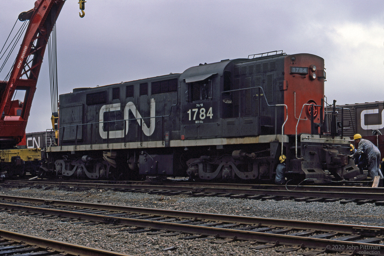 CN people are working with crane CN 50000 to get MLW RSC-14 CN 1784 back on track after a derailment in Halifax.
The RSC-14's were RS-18's re-trucked by CN to spread their weight across six axles, for branch lines with light rail in the Maritime provinces. 
The A1A trucks were taken from retired RSC-13's and RSC-24's which previously served that assignment. 
RSC-14's were derated from RS18 original 1800 HP to 1400 HP, probably the safe limit for the A1A traction motors.
Location within Halifax is unstated, mapped to vicinity of Fairview.