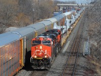 CN 319 is a unit train of windmill blades, westbound on Oakville Sub track 2 passing CN Aldershot Yard.<br>
319's head end has just crossed Grindstone Creek bridge. CN train 422 on track 1 will proceed east shortly.<br><br>
Another railfan told me he heard the axle count was 300. IF we got the axle count and math correct:<br>
Deduct 12 loco axles leaves 288 flatcar axles, divided by 4 equals 72 flatcars.<br> 
Each pair of blades occupies 3 flatcars, making 48 blades on the train.<br><br>
It worked out well that my wife finished her shopping at the big blue and yellow store near Aldershot East around the time I learned this train was on the Halton Sub, heading towards us.    
