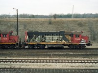 CN 7508 is towed away from the scene of its mishap by another hump switching set: GP38-2 CN 7501, slugs CN 510 and 5??, and CN 7506. Likely going to Macmillan Yard Diesel shop first. It got repaired and returned to work the Macmillan hump.<br><br>
A good view of its EMD V 16-645E 2-stroke diesel prime mover is afforded by the loss of 7508's hood doors, with the same-colour Roots mechanical supercharger at the cab end, and the main alternator below it.<br><br>
The two-stroke diesel does not have an inlet stroke, so it cannot start or run without supercharging to force air into the cylinders in the brief time that the inlet ports are uncovered by the pistons near bottom of stroke.


