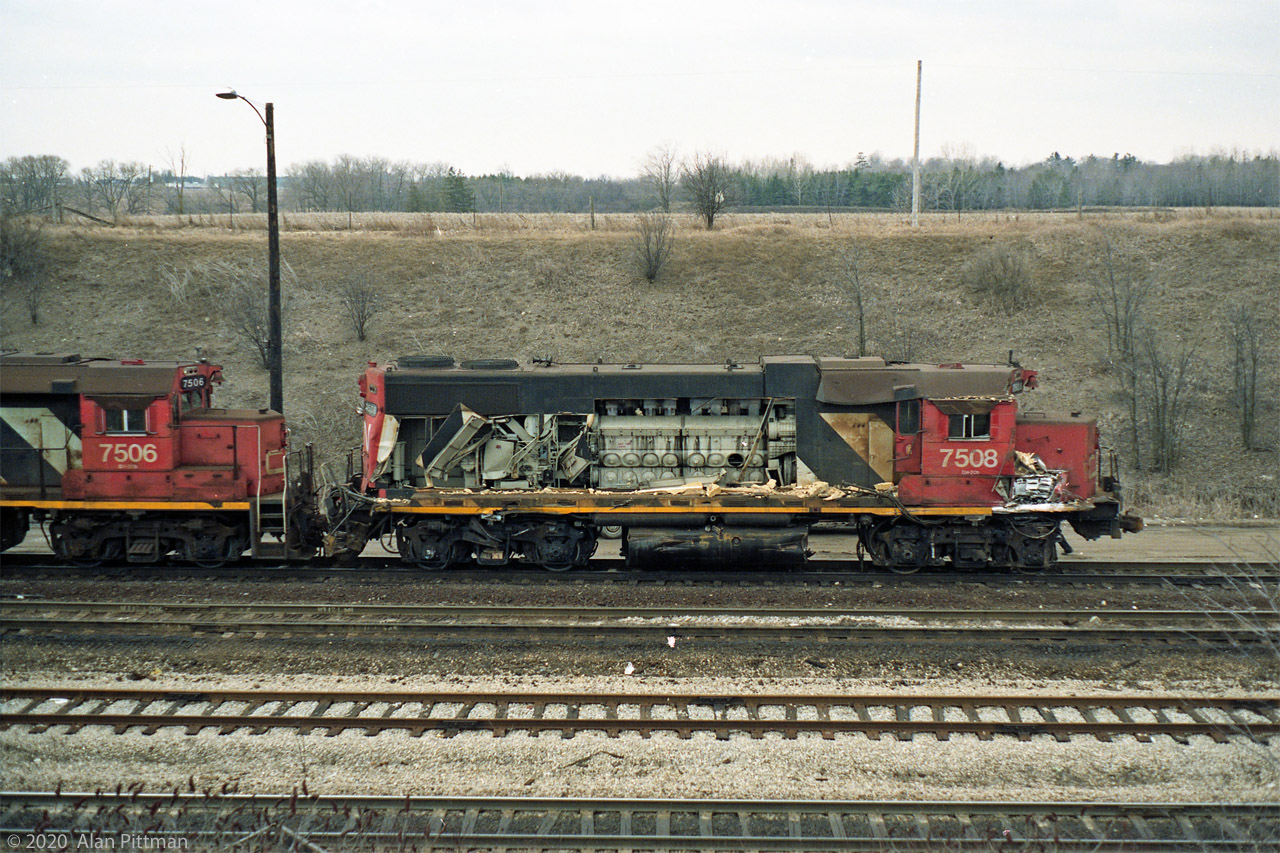 CN 7508 is towed away from the scene of its mishap by another hump switching set: GP38-2 CN 7501, slugs CN 510 and 5??, and CN 7506. Likely going to Macmillan Yard Diesel shop first. It got repaired and returned to work the Macmillan hump.
A good view of its EMD V 16-645E 2-stroke diesel prime mover is afforded by the loss of 7508's hood doors, with the same-colour Roots mechanical supercharger at the cab end, and the main alternator below it.
The two-stroke diesel does not have an inlet stroke, so it cannot start or run without supercharging to force air into the cylinders in the brief time that the inlet ports are uncovered by the pistons near bottom of stroke.
