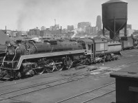 "Bullet Nose Betty" 4-8-2 CN 6070 is resting over the ashpit near Spadina Roundhouse in Toronto in 1955.<br><br>
CN had 20 class U-1-F engines 6060-6079 built by MLW in 1944, retired by CN 1959-61. Three survive.<br>
The tender is full of coal, likely filled at the coal tower on the other (west) side of Spadina Road Bridge.<br>
Until 1962 the tallest building in the British Commonwealth was the Canadian Bank of Commerce tower (completed 1931), visible just left of CN's water tank.<br><br>
James Victor Salmon photo, Courtesy of Toronto Public Library. Caption by John Pittman