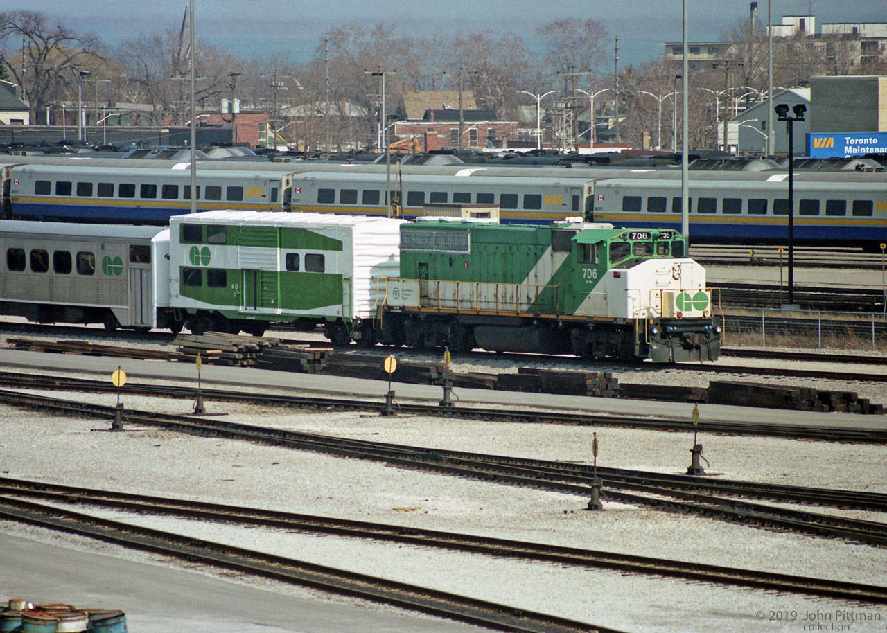 Retired GO Transit equipment, including GP40-2w GOT 706 and unique 40' boxcar CN 561747 (done up like a GO multilevel coach), seen on a storage siding in Willowbrook Yard. Early spring of 1991 (or 1990).
All but one of GO Transit's GP40-2W's were acquired by CN in 1991, GOT 706 becoming CN 9673.
On CN the ex-GO locomotives retained green & white paint for a while, minus the white GO plates from the handrails.
Beyond the fence are CN Oakville sub main lines, then VIA yard tracks with LRC coaches (in service), and quite a fleet of VIA Budd RDC's behind them (many stored/retired pending disposal).