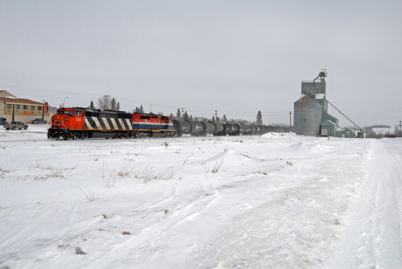 CN 453 is seen passing the former Alberta Wheat Pool elevator at Kitscoty Alberta. Both CN 5550 and BCOL 764 are long off the roster these days and 453 began terminating at North Battleford shortly after this photo was taken. The elevator is still alive and well as of 04/2020.