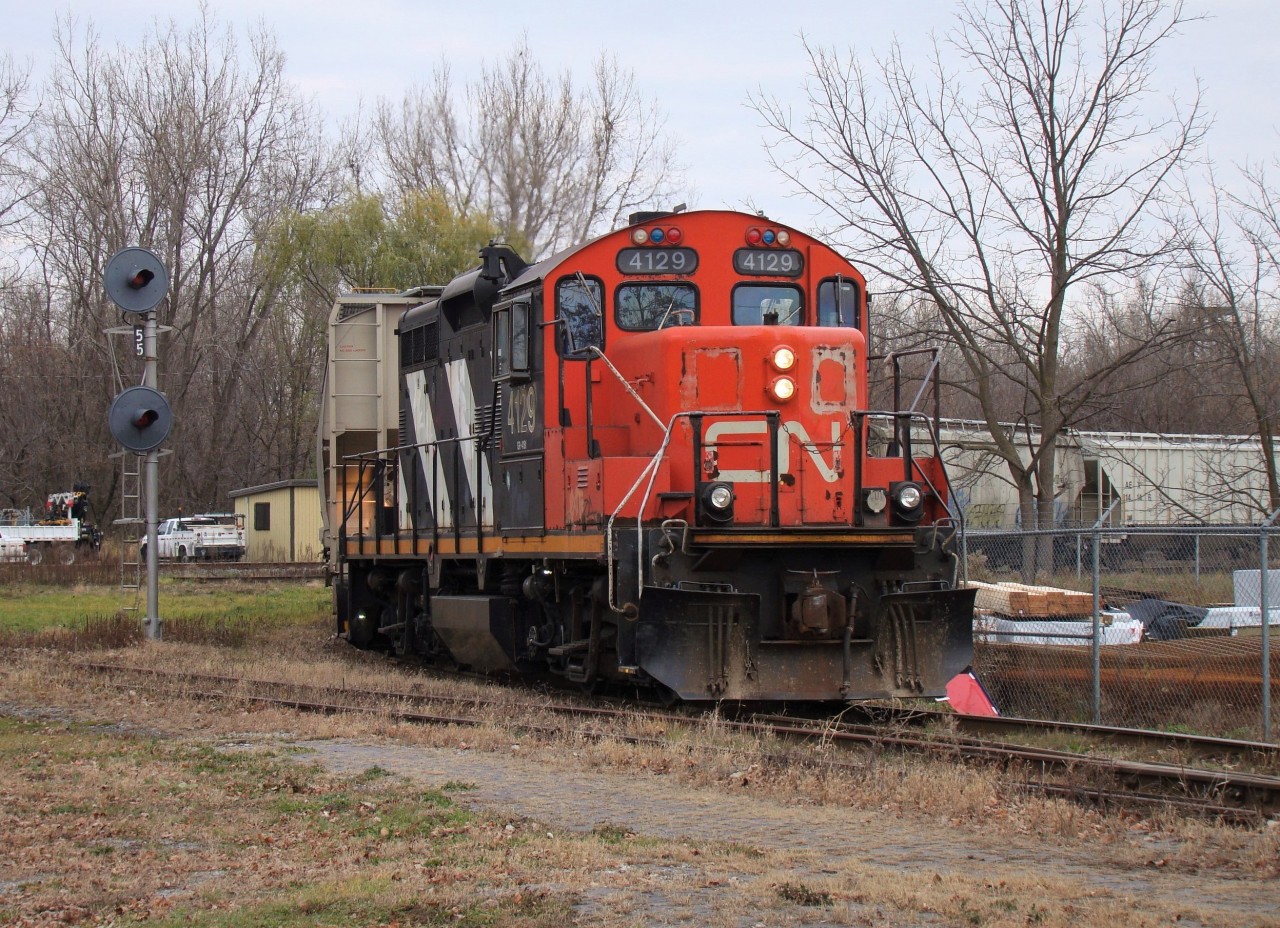 CN 4129 backs a handful of interchange cars into the CP Chatham Yard, passing by the former site of the C&O Chatham Depot.