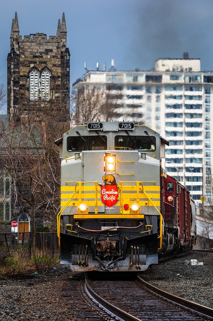 With Toronto to Buffalo tonnage on the drawbar, Canadian Pacific SD70ACU 7015 (nee 9126) puts the 'H' between the T&B as it guides train no. 246 through downtown Hamilton on the former TH&B. Pre-dating the construction of the railway by over a quarter-century, the striking MacNab Street Presbyterian Church towers over the TH&B as it has since the very beginning.