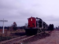 Passing Carleton, Mileage 40.9 of the Borden Subdivision, CN's Train 115 was just eight minutes away from the ferry dock at Borden, Prince Edward Island, on Saturday, October 12, 1968.  No one had set the flag, so the trio of RSC-13s motored by with a baggage car and combine at 912 a.m.  The abbreviated train had left Charlottetown, the provincial capital, at 730 for the 42.4-mile run.  I had chased the same train in May of 1968, and it had then included a full coach, rpo and three express baggage cars as well as a steam generator.   In both cases, the cars were transferred to the S.S. Prince Edward Island and off-loaded at Cape Tormentine, on the New Brunswick shore.  From there, the train continued its 6-hour run to Moncton.   I had wanted a shot at Carleton as I had graduated from the similarly named university in Ottawa in May 1967. <br> <br>

Leading RSC-13 1733 was one of 35 similar MR10 units on CN.  They had arrived from MLW beginning in mid-1955 as a uniquely Canadian unit.  Their A1A trucks made them suitable for CN's many branchlines.  Tested from coast to coast, they settled in Southwestern Ontario until the mid-1960s.  With CN's determination to retire their 1200hp CLC roadswitchers, the MR10s found new life in the Maritime Provinces.  Several came to Prince Edward Island and promptly bumped a pair of H12-44s from the mainline passenger trains and 70 Ton GE's from many secondary routes, excluding those south of Mount Stewart, east of Charlottetown.   By the mid-1970s, their 6-cylinder McIntosh and Seymour inline 1,000hp engines were out of favor on CN.  So, they were retired, and their trucks placed under de-rated and lightened RS-18s in a program conducted by the Moncton Shops.  For example, 1733 was retired on Wednesday, October 8, 1975, and its trucks installed under RS-18 3845, which became RSC-18 1752 when it re-entered service on Friday, October 24, 1975.   CN assigned 1750 through 1756 to Charlottetown in 1979.   On Wednesday, August 25, 1993, CN sold the unit for scrap to Met-Recy in Laval, Quebec.  It was resold to the Deleware-Lackawanna but was subsequently rejected and presumed scrapped.  

