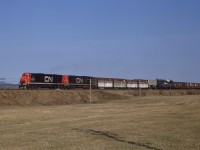 At 9 a.m. on Wednesday, May 1, 1968, CN Train 406 is just east of St. Basil, New Brunswick near Mileage 213 of the Napadogan Subdivision.  The two almost new C-630Ms, 2022 and 2025, are en route to Moncton.  During the night, they had traversed the hill and dale National Transcontinental route from Joffre near Quebec City to Edmundston.  Nearly a decade later, that trip would take them across the Pelletier cut-off that linked the former NTR line directly to the water level route along the St. Lawrence River. <br> <br>

CN sampled four-axle second-generation power from both MLW and GMDL in the early 1960s in the form of C-424s, GP35s and GP40s.  As with many railways, the translation of high horsepower to effective tractive effort through four traction motors did not prove overly successful.   Hence, following demonstrations of UP C-630s and EMD SD40xs in 1966, CN shifted their orders to exclusively six-axle units between 1967 and 1972.   MLW supplied two sample units, 2000 and 2001, in August 1967 followed almost immediately by an order for 42 additional C-630Ms.  They rode on hi-adhesion trucks newly designed by Dofasco in Hamilton, Ontario, that featured a very short 11' 2" wheelbase.  The MR-30 class units served primarily east of Montreal during their lifetime until CN replaced them on priority trains with GE Dash 8-40CM in the 2400 series beginning in 1990.  As CN retired the units, the Cape Breton and Central Nova Scotia Railway obtained nine of these "Big Alcos," including the 2022, which uniquely became a parts source in Sydney, Nova Scotia.