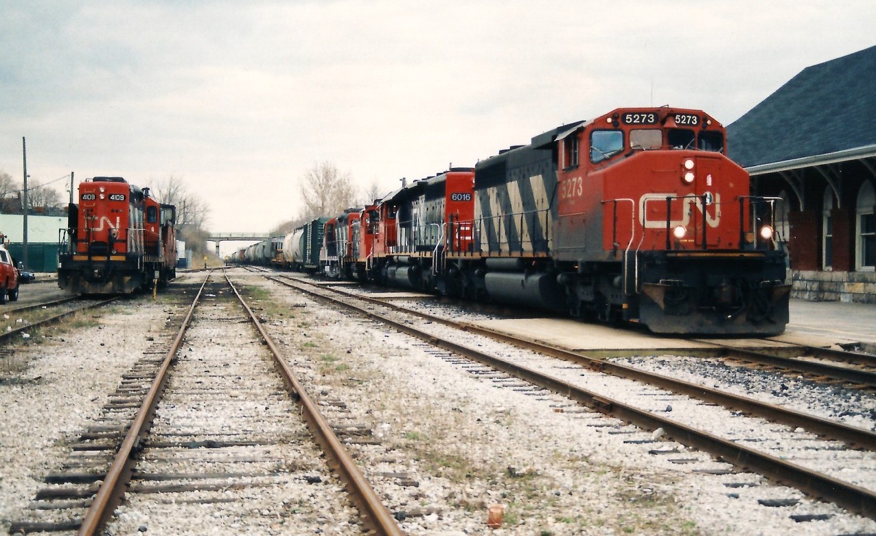 CN train 421 is departing Kitchener as it passes the CN offices and the VIA Rail station with 5273, 6016, 1375 and 4102. My notes show that 421 had set-off 9 cars before departing westbound at 18:45 ahead of the westbound VIA Rail #87. CN 4109 is seen to the left and was the assigned power for Guelph local 580. 

25 years later SD40-2(W) 5273 is still active and operating not too far from Kitchener assigned to Brantford as seen in these excellent photos.

 

http://www.railpictures.ca/?attachment_id=40821

 

http://www.railpictures.ca/?attachment_id=40693

 


http://www.railpictures.ca/?attachment_id=39606