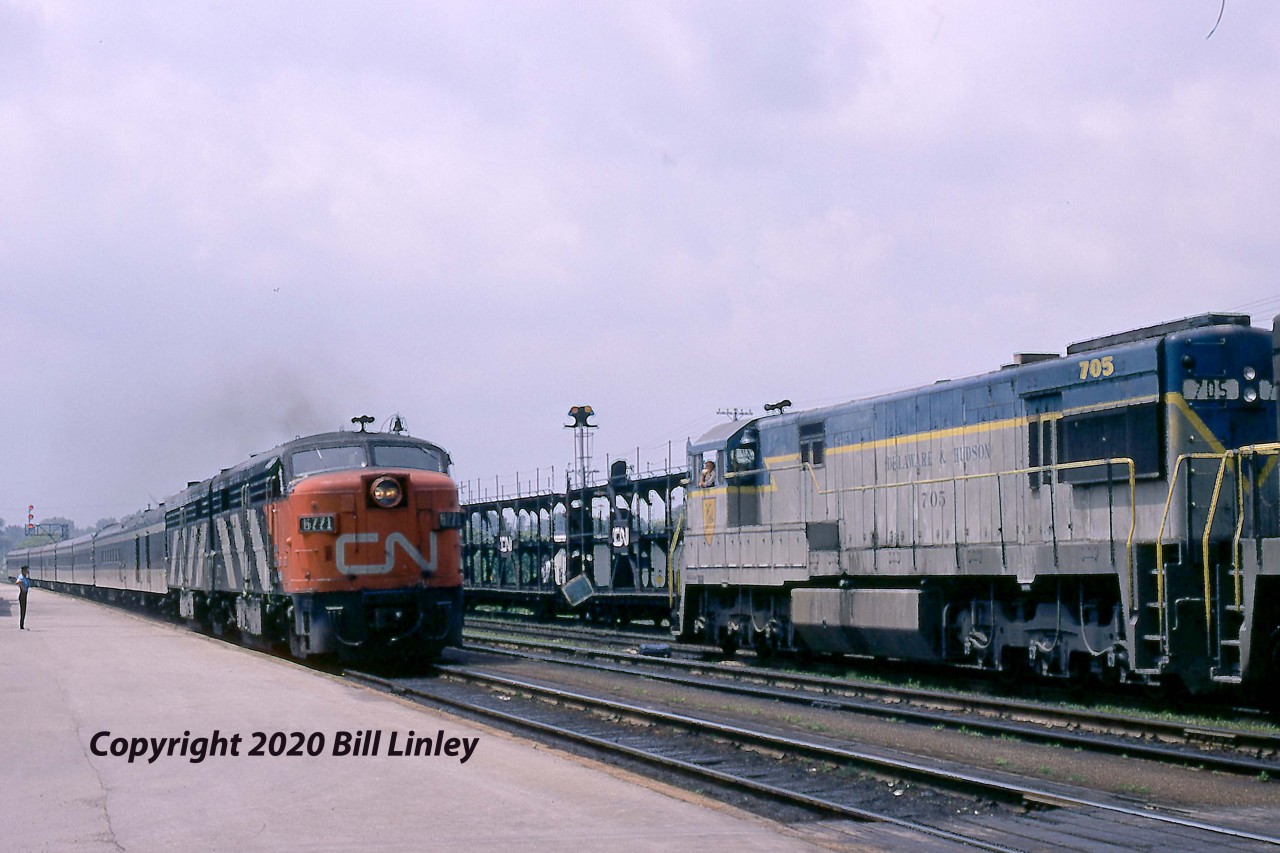 CN Train 60, The Rapido, on a 5-hour, two-stop schedule from Toronto to Montreal, speeds past a detouring D&H freight in Belleville, Ontario, on Thursday, June 22, 1972.  FPA-4 6771 was one 27 built by MLW for the CNR in the spring of 1959.   Retired by VIA in 1989, it was sold stateside in 1990 and, ironically, was painted in D&H colours in 1993 while operating out of Cumberland, Maryland.  In 2003 it entered service on the Cuyahoga Valley Scenic RR in Independence, Ohio, near Cleveland.  D&H 705 and 706 are changing CN crews and will soon depart for Toronto and Buffalo.  They were part of a parade of detours running over CN and CP following the devastating impact of Hurricane Agnes on the Erie Lackawanna mainline.  The two GE U30Cs were part of an order for a dozen units delivered in 1967-68 that were sold to the National of Mexico a decade later.