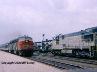 CN Train 60, The Rapido, on a 5-hour, two-stop schedule from Toronto to Montreal speeds past a detouring D&H freight in Belleville, Ontario, on Monday, June 26, 1972. FPA-4 6771 was one 27 built by MLW for the CNR in the spring of 1959. Retired by VIA in 1989, it was sold stateside in 1990 and, ironically, was painted in D&H colours in 1993 while operating out of Cumberland, Maryland. In 2003 it entered service on the Cuyahoga Valley Scenic RR in Independence, Ohio, near Cleveland. D&H 705 and 706 are changing CN crews and will soon depart for Toronto and Buffalo. They were part of a parade of detours running over CN and CP following the devastating impact of Hurricane Agnes on the Erie Lackawanna mainline. The two GE U30Cs were part of an order for a dozen units delivered in 1967-68 that were sold to the National of Mexico a decade later.