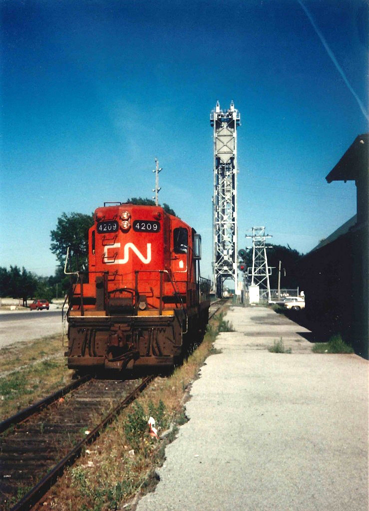 High nose GEEP 4209 has the greenlight (Signal 190) to cross the Welland Canal Bridge #20.  The unit had set off a series of covered hoppers at the Goderich Elevator (Port Colborne Grain Terminal) and was returning light to the CN Nickel Yard.  After the Elm Street spur to Robin Hood was removed in 1983/84, CN removed their Port Colborne Road Switcher and all plants on the East and South West side of town were switched by GP9's out of Niagara Falls.  The Lift Bridge was manned 24/7 for the 9 1/2 month shipping season, and high operating costs were the driving factor to remove Bridge 20 and Thorold South Bridge 10 tin 1997.  The 1925 Port Colborne station was boarded up in 1984 after the Road Switcher and Freight Car services were ended.  The east portion of the station served for a period of time as Trilliums HQ, and the center houses the popular Smokin Buddha restaurant.