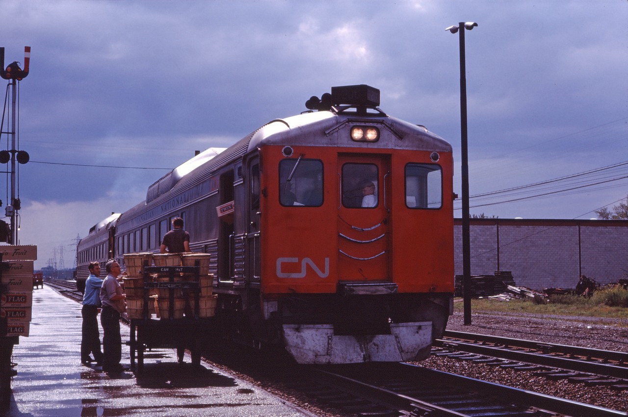 Between showers on a summer afternoon in 1963, train No. 646 from Niagara Falls and Hamilton handles express traffic at Burlington. If the train was on time, it's 3:29 PM and the train will arrive in Toronto at 4:15 PM. Note the fruit on the baggage carts, visitors in the cab of the RDC, the train order semaphores and the "flag stop" lights on the mast of the train order signal. If you look closely, you can also see the van of a CP train in the distance. My, how times have changed...