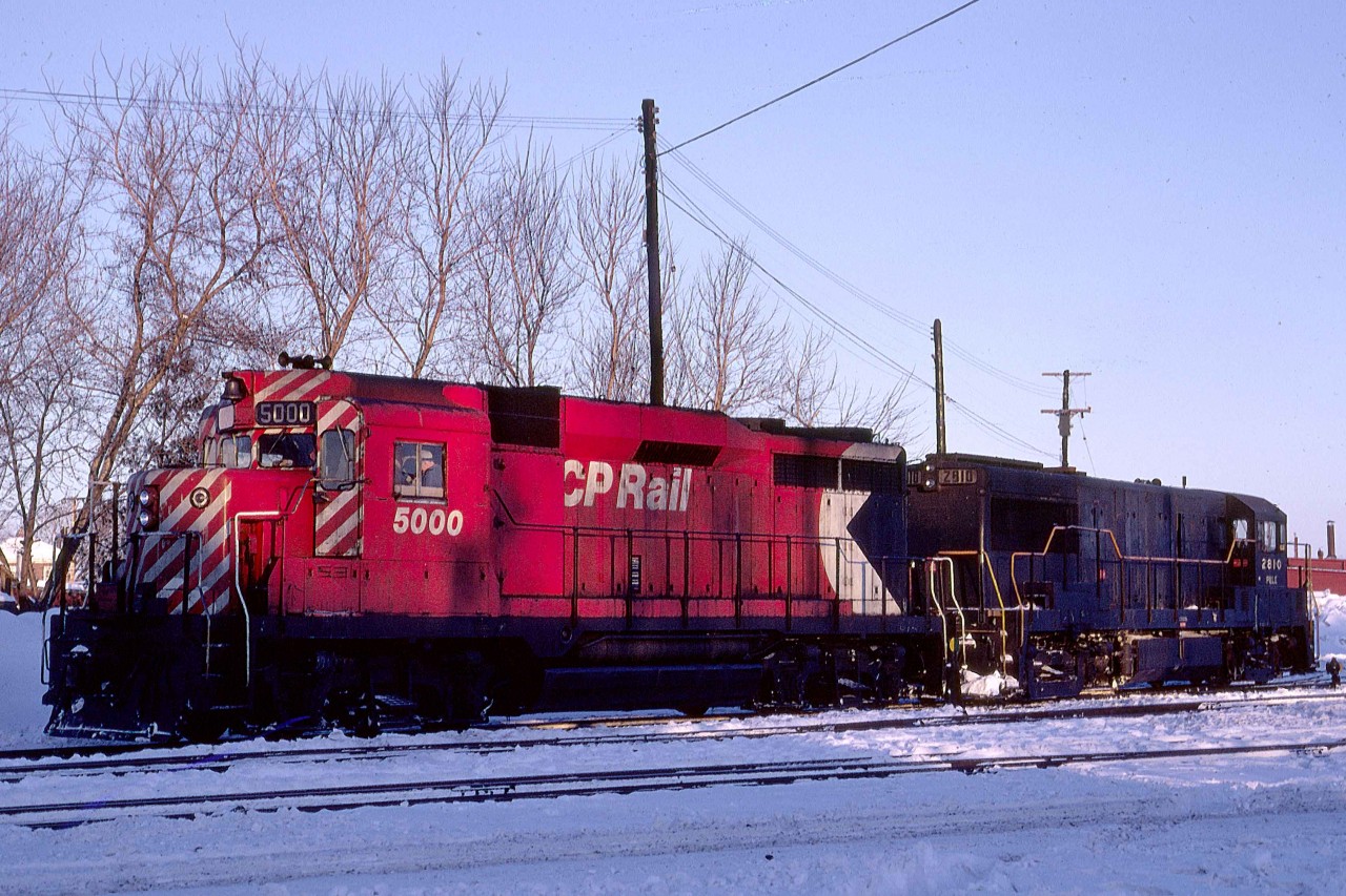 CP Rail 5000 pauses on its way back to Train 1-915 from the Smiths Falls, Ontario shop track in January 1974.  

The GP30 was one of just two on CP Rail.  Delivered as 8200 on Saturday, March 30, 1963, with serial A-2006, it was the CPR's first turbocharged unit.  GMDl gave trade-in credit for wreck damaged F9B 1902.  C-424 8300 followed a month later.  GMDL had replaced the two-year-old GP30 model with the GP35 by the time the CPR placed a followup order for a dozen units in June.  MLW received the next order for 32 C-424s in September 1964.  CPR renumbered the 8200 to 5000 on Monday, April 12, 1965.  It is now displayed in Edmonton, Alberta.       

The CPR was chronically short of motive power, especially during the busy winter season from 1963 through 1975.  In the following decades, CP Rail often experienced motive power shortages.  Leased P&LE U28B 2810 (GE 1-1966 #35866) is today's solution.  This unit travelled far and wide from western Pennsylvania during its career before settling on TTI, the Transkentucky Transportation Railroad based in Paris, Kentucky.   It was one of seven former P&LE U28s that helped TTI haul coal fifty miles to an Ohio River transload at Maysville in northeastern Kentucky.  Renumbered to 249 it was scrapped on the TTI.  The TTI started in 1979 and became a CSX subsidiary in 1981.  Since 2017 it has been reduced to transloading and car storage in Paris.