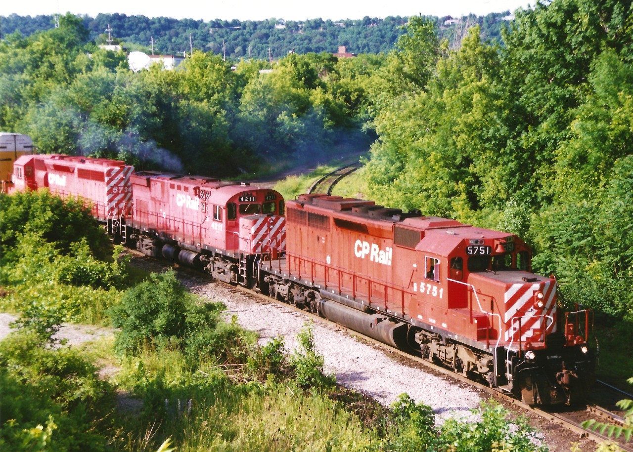 A northbound CP train waits to continue it's journey on the Hamilton Subdivision as it pauses near the Dundurn Street bridge in Hamilton with 5751, 4211 and 5734. Luckily, the early morning sun is high enough that most of the shadows have retreated away from the power. This location has changed considerably over the years including the installation of a second track a couple years after this photo was taken.