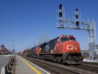 CN 368 with CN 2281 & CN 5763 for power is passing underneath a new signal gantry which was put into use just this past Wednesday, replacing a much older signal gantry. At left the long-term parking at Dorval Station is nearly empty. Normally it would be just about completely full, but today it only had a single car parked there.
