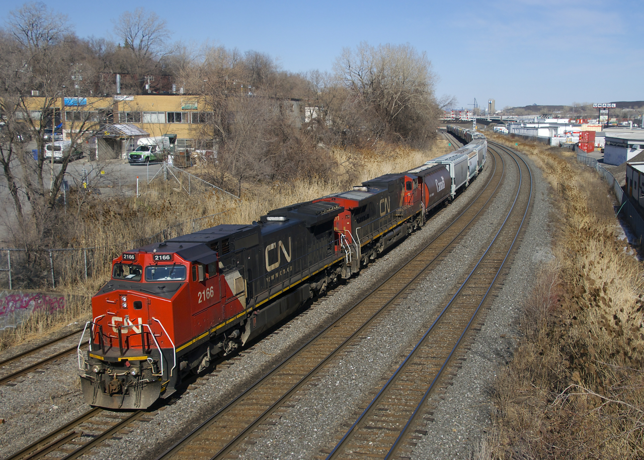 CN 527 with CN 2166 & CN 2201 is advancing west before backing up and setting off a cut of CP grain cars on Track 29.