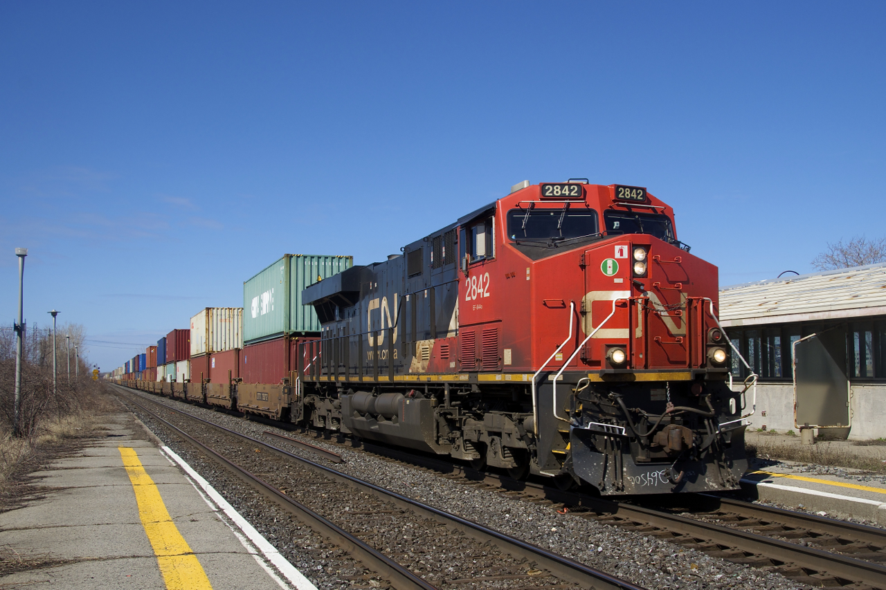 A late CN 120 is passing through Dorval with CN 2842 up front and CN 2905 mid-train. Soon it will enter Taschereau Yard, where additional power and cars will be picked up before it departs for Halifax.