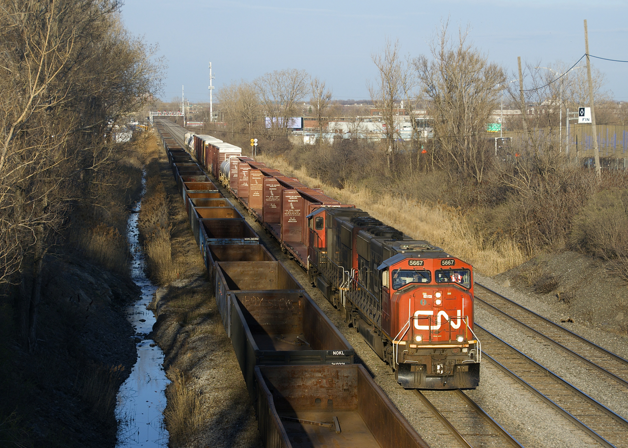 Sunset isn't too far away as a short CN 323 approaches Taschereau Yard with SD75I's CN 5667 & CN 5707 for power as it returns from Vermont. At left is a string of stored gondolas.