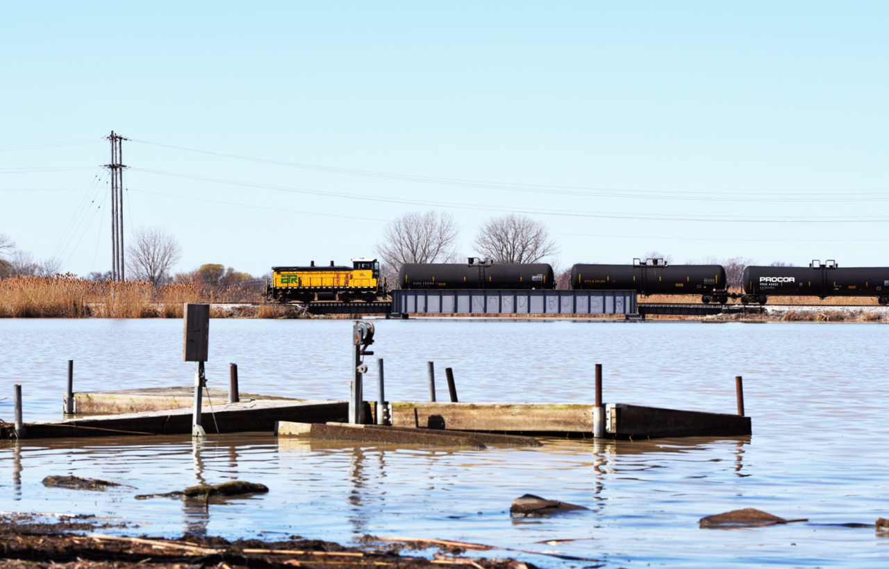 With about 30 tanks in tow ETR 107 crosses over the main branch of River Canard on it's way to Amherstburg and the most Southern rail served industry in Canada.