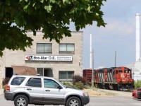 There is no hiding the fact that this was a very hot summer day when this scene transpired along CN's short Townline spur in Milton on July 6, 2016. The burnt grass, lowered car windows and patio umbrella just made me want to find some shade. The crew of local 551 have paused briefly to hook up to some empty centre beam cars at a lumber yard before heading back to the mainline. Lead unit GP9RM 4125 shows off the scars of a long grueling career on its nose. The building in the foreground was once part of the lumber yard but has since been leased out. 