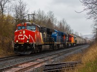 The heads up for these lashups are always appreciated. In this particular case, CN 394 has a colourful lashup of CN 3152, GECX 2037, CN 5797 and QNSL 528. The QNSL is a former Australian BHP unit that got rebuilt by Progress Rail in Tacoma, Washington, and is in transit to get to Quebec's north shores. CN 3152 for whatever reason has the entire conductor side window area painted black, which seems to have been this way for well over a year, if not from when it left the GE plant in Fort Worth. Near the end of the train sandwiched in is CN 2801 as DPU, not seen here of course. No doubt I made the trip down for the QNS&L.
<br><br>
With rain drizzling down, I figured the bridge off of Homestead Avenue just a short distance up the hill from Bayview would be a good location. The tree branches proved to be a challenge, so a little bear crawling to get under the bridge was done. Not to increase my rants about Hamilton parking enforcement, but Homestead Avenue is off limits to parking. The locals here don't seem to care as long as the road isn't blocked, but a reminder should be served that Hamilton's parking enforcement does not mess around in case anyone wants a shot here. Nonetheless, that likely further explains why pictures from this location are uncommon. While this spot does not work well when the sun is out, it seems perfect during a light rainfall. I will be back at some point, though probably on my bicycle. 

