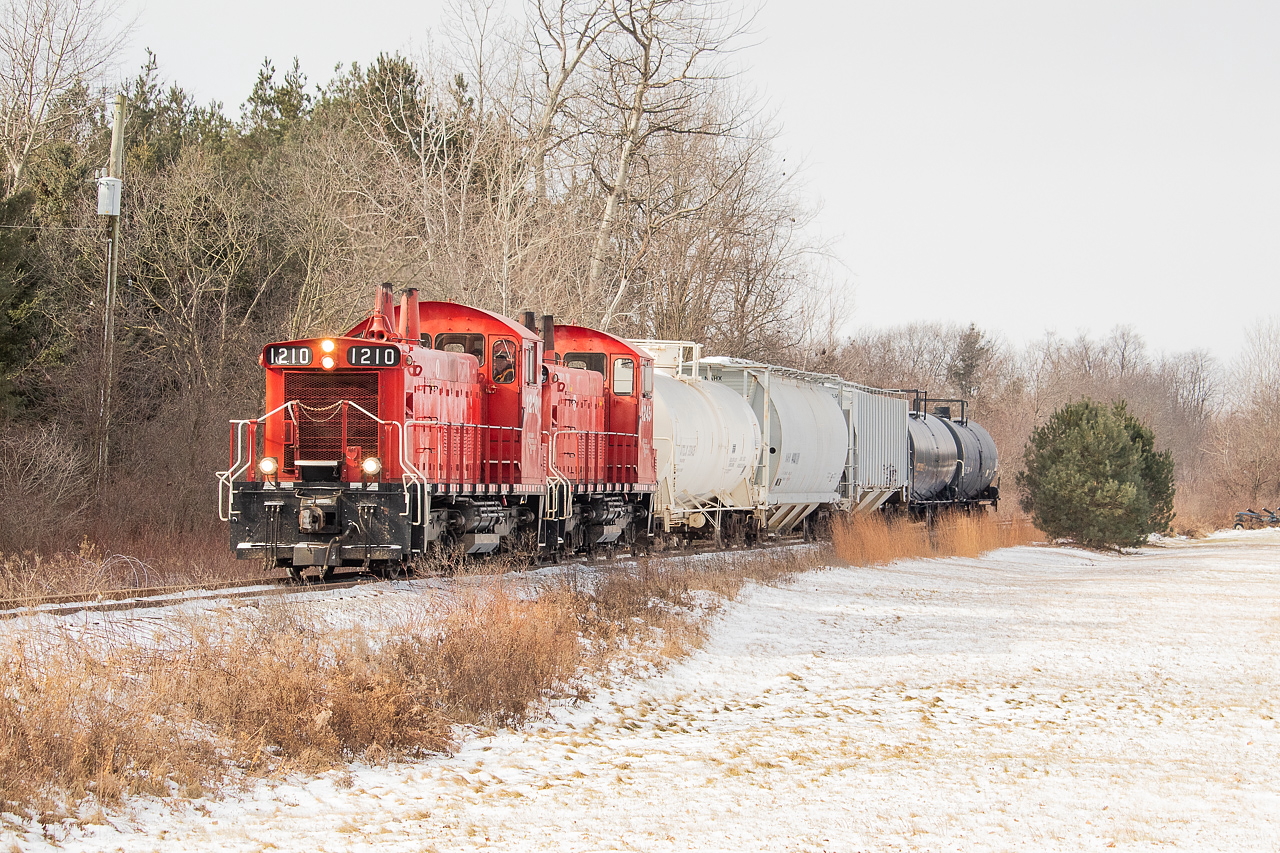 Since this location came up in the recent April Fool's posts, I figured no time like the present to make good on a promise and share this one. The OSR Cayuga Clipper is eastbound on the Cayuga Spur, approaching the Plowman's Line crossing just west of Courtland on the western edge of Norfolk County - a place that those of you who know me probably get tired of hearing me talk about. The two hoppers pictured would be set off there, and they would make a lift too before heading back west. Questions are many about the future of the Cayuga and subsequently, the future of rail in Norfolk. The six or so miles of the in-service portion of the Cayuga that runs on Norfolk soil to Courtland is the last vestige of rail in the County, a place that at over time had eight different lines traversing the landscape: Brantford, Norfolk & Port Burwell Railway; Great Western Railway; Hamilton & Lake Erie Railway; Lake Erie and Northern Railway; Michigan Central Railroad; Port Dover and Lake Huron Railway; South Norfolk Railway; and the Toronto, Hamilton & Buffalo Railway. Some of the preceding names changed over time of course. To see a map, the County has a heritage railway map on their website. On a somewhat personal and historical note, the South Norfolk Railway, which ran from Simcoe to Port Rowan, passed through the sandy fields of the farm that has been in my family for over a century now, and I have an original crossing sign from it hanging in my parents' basement in Simcoe that we rescued out of the barn a number of years ago. That particular railway ceased operations in 1965. If any of you are sitting on some classic shots from the area, I sure would love to see them. They seem to be hard to come by, though there are a couple gems on this site already.