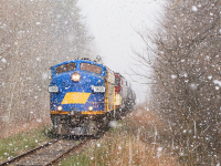 After working the elevator in Courtland for more then likely the final time, OSR's weekly Cayuga job throttles up after flagging the previous crossing due to the age and reliability of the equipment on the line. I had originally intended to do a crossing shot looking down the road. With a very abrupt snow squall dropping gigantic snowflakes I quickly adjusted my position. With the snowflakes blowing in from the North and the sun scooting out from behind the clouds a few minutes before the train showed up, it provided this opportunity for a photo with snow and sun. 