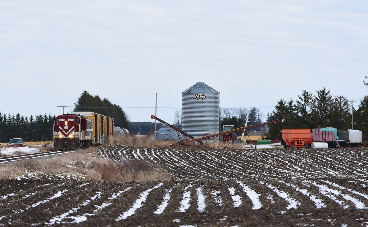 Ontario Southland's St. Thomas job rolls past one of the many farm yards which dot Southwestern Ontario with ex. SOO 383 in lead and 4101 in second.