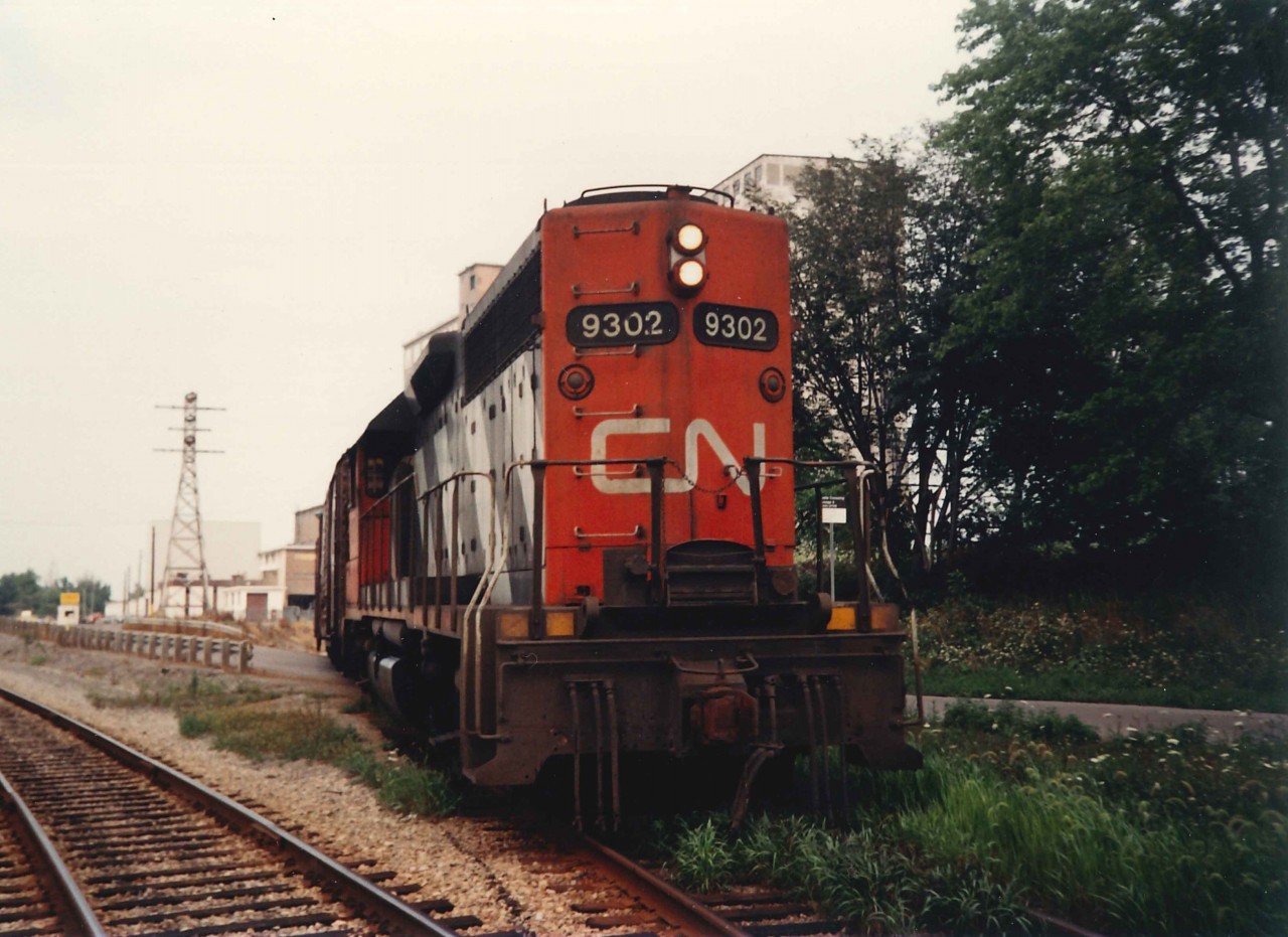This photograph is a follow-up to James Knott's recent photo taken at the former Robin Hood Flour Mill.  This shot does not have the same artistic balance, but it was unusual to find GP40's on swithcing duties at this location (CN had only 16 of these units on the roster).  These movements were still coming out of the Fort Erie yard, and that day 9302 worked the Canada Starch facility (CASCSO) as well.  The flour milling operation ran till the mid-2000's.  At the time Port Colborne was Canada's second largest flour milling center behind Montreal and the town can trace its flour milling legacy back to the 1780's when the Upper Canada's 3rd grist mill was established for flour production the shores of Lake Erie by Pennsylvania loyalists