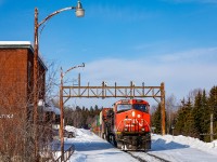 <b>A Second to Spare at Swastika</b>
There are close calls. And then there are the mop your brow and curse to the heavens, way too close for comfort, close calls. As Canadian National detour train no. 188 rolled around the bend on ONR's Ramore Subdivision at Swastika, Ontario, I experienced the latter. 

The morning of February 23rd looked promising. With word that 188 (a Hornepayne, ON to Taschereau, QC detour train) would be making a daylight run over the ONR to Englehart, I devised a plan. Knowing that 188 had departed Cochrane at 0700, I pressed north along the Trans-Canada Highway to Matheson, where a handsome ONR station still stands. With a general understanding of ONR's run-times, I'd arrive at Matheson shortly after 0800 to find a perfectly lit scene, shoot at the station and the chase would be on. In my head, everything played out flawlessly. In reality, I was dead wrong. While driving up to Matheson, I had unknowingly committed one of railfanning's cardinal sins: driving towards an oncoming trains. And yes, the train managed to sneak by me in the handful of spots where the railway does not parallel the highway. While a silent scanner on the drive north should've been my first indicator that something was wrong, every passing minute at Matheson sealed my fate. Now, almost 40 minutes after arriving at Matheson, I was starting to get very nervous. 

Following a horrible gut feeling that 188 had (somehow) snuck by me along the way, I started back towards Swastika. In my mind, Swastika is the 'signature shot' on the line and I wasn't going to miss it. About 10 miles out of Swastika, and still with no sight of the train, the scanner crackled to life. "ONR equipment defect detector, mile 29.6 no defects". SHIT. Swastika is located at mile 26 and I'm at least 5 miles behind the train. Now the chase was really on. Literally flying into town, I arrived at the station and threw my car into park - engine still running and my legs trembling. By the grace of god, the train hadn't gone by the station yet, but I didn't have much time. As I ran up a snow-packed set of stairs to track-level, CN 2561 was already coming around the bend. Now, I'm sprinting down the platform as the train is coming at me. Its absolute chaos. Stumbling into place, I abruptly raise my camera and fire a rapid burst of photos. In total, I fired 8 hectic frames. This photo was the 8th. Between the first and last frame, a total of 2 frantic seconds had eclipsed. Now that is what I call too close for comfort. 

