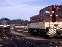 Toronto Hamilton & Buffalo SW9 58 rests near the railway's Aberdeen Roundhouse in Hamilton, Ontario, on Sunday, July 7, 1968.  GMDL built the 1200hp switcher in nearby London, Ontario, in January 1951, serial A-124, as their 25th production unit.  The 58 was the last of four ordered by the TH&B in 1950 to complete dieselization of their switching services.  Retired in May 1988 and sold to Atlas Steel in Welland, it was resold that year to Lukens Steel's Brandywine Valley Railroad in Coatesville, Pennsylvania, as their first 8206.  It was transferred to the Upper Merion and Plymouth at Conshohocken Pennsylvania in 1991, where it continues to operate as their second 9007. <br> <br>  Facing the switcher is NYC E8A 4003 fresh from an early morning run from Buffalo on Toronto-bound Penn Central Train 371.  Connecting Train 57 had departed Grand Central Terminal the previous evening with coaches and sleepers for Toronto.    My friend, Bruce Mercer, was on duty at Port Credit that morning and reports that CP RS10 8575 handled the last 39.3 miles from Hamilton to Toronto as Train 322.<br> <br> New York Central 4003 was built as an E7A at LaGrange in March 1945 with serial 2868.  It was involved in a wreck at Conneaut, Ohio, on March 27, 1953, and was rebuilt by EMD as an E8A.  Not long after, it was on the September 1956 cover of Trains Magazine in an image by Phil Hastings and featured in the particularly famous story by David Morgan: The Mohawk That Refused to Abdicate.   The unit was retired in June 1973.<br> <br> The TH&B completed its line between Waterford and Welland, Ontario, via Hamilton in 1895.  NYC (73%) and the CPR (27%) purchased the railway in 1895.   In 1977 CP Rail bought the former NYC shares and merged it entirely in 1987.