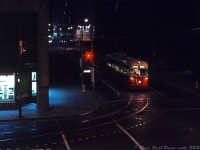 <i><b>Night Owl Trip:</b></i> Operating on an all-night fantrip, TTC PCC 4732 (one of the 48 1947 Pullman-built A13-class cars acquired secondhand from Birmingham, Alabama) poses for a night-time photo op by the streetcar stop at the corner of Bay Street and Albert Street in downtown Toronto. The car is turning on City Hall loop, an on-street loop of track off Dundas running clockwise from Louisa-James-Albert. Lurking in the shadows of early 1970's street lighting are the Old City Hall (dark, to the right), Eaton's Annex store (to the left), and Eaton's flagship Queen Street Store (in the distance at Albert & James). At this time, Albert Street still ran all the way from Bay to Yonge. Also worth noting is the blue illuminated street sign, which started appearing on main Toronto thoroughfares in 1967.<br><br>It had been common since the 1960's for railway societies and individuals (both local and visiting) to charter streetcars for private trips touring around the city, posing for photos, and to visit different transit carhouses, garages, terminals, loops, etc along the way. Standard practice during a photo stop was to sign a car up for past and present routes that operated in the area. In this case, 4732 has been signed up as a Dupont car bound for City Hall (loop), even though the Dupont route vanished almost a decade earlier in 1963 when the University subway line opened (see the Bill Thomson's photo <a href=http://www.railpictures.ca/?attachment_id=25110><b>here</b></a>).<br><br>In the coming years, the new Eaton Centre development would close some of the local streets and eliminate City Hall loop. The Eaton's Queen St. store would get <a href=http://www.railpictures.ca/?attachment_id=35307><b>demolished</b></a> to make way for further mall expansion (once the new flagship Eatons store at Dundas was opened), and Albert Street would be truncated at James. <br><br><i>Robert D. McMann photo, Dan Dell'Unto collection slide.</i>