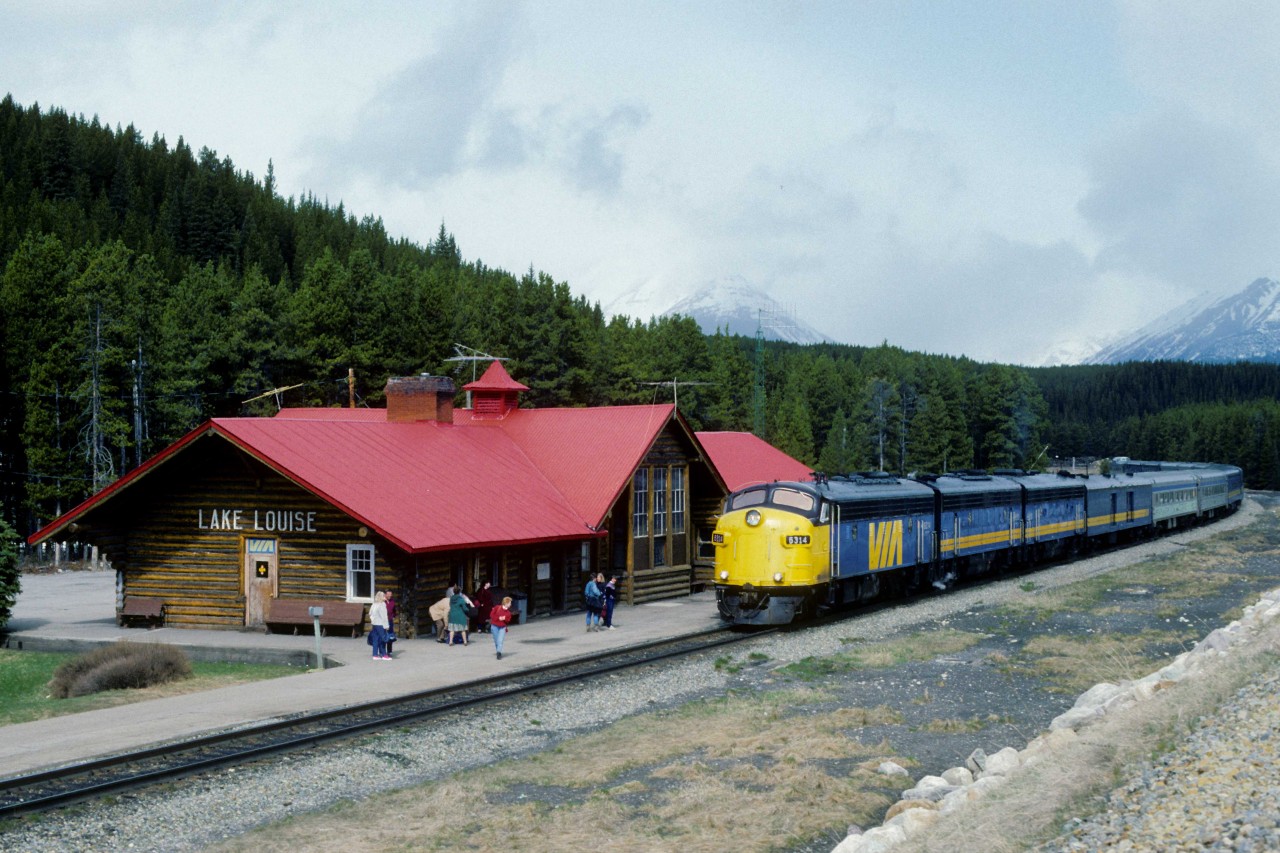 The Canadian arrived at Lake Louise station at 1140 on Saturday, May 17, 1986.  VIA FP9Au 6314 leads two ex CN F9Bs 6616 and 6617.    VIA extended the life of fifteen similar ex-CN units before purchasing its first F40PH-2 in 1986.   CN remanufactured former CN FP9 6527 at its Moncton Shops in New Brunswick in 1985.  

The former station is now the Station Restaurant that includes the heavyweight dining car "Delamere."  The last Canadian passed here in January 1990 due to massive government cuts to the VIA network.  The eastbound is at Mileage 116.6 of CP Rail's Laggan Subdivision on the original CPR alignment, as seen from the more recent lower grade line.