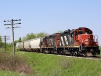 The distant cry of a pair of veteran EMD prime movers at full throttle can be heard through the open car window as I approach the Grand River bridge in Kitchener's east end, soon a pair of worn GP9RM'S storm over the bridge before I can even get the camera out of its bag. Looking at my two young boys in the back seat there are no need for words as the big smiles say it all. Soon we find ourselves going full speed in the opposite direction. I have to admit I love these rebuilt Geeps. CN has definitely gotten it's money's worth out of them and no other Class One railroad has gotten the mileage out of GP9's like CN, after all they have been rolling for their original owner for well over half a century. We finally get ahead of the train when we reached Mosborough but still only had seconds to spare. In the image here the two Geeps have a short train in tow as they pass a short row of surviving line side telephone poles, just ahead the remnants of the one time short siding located here, which can still be found in the weeds severed from the main. I'm sure as time allows Metrolinx will eliminate both. 