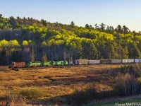With the sun peeking over the hillside, train 907 is westbound, with a 5-pack of power at Clarendon, New Brunswick near sunrise. 