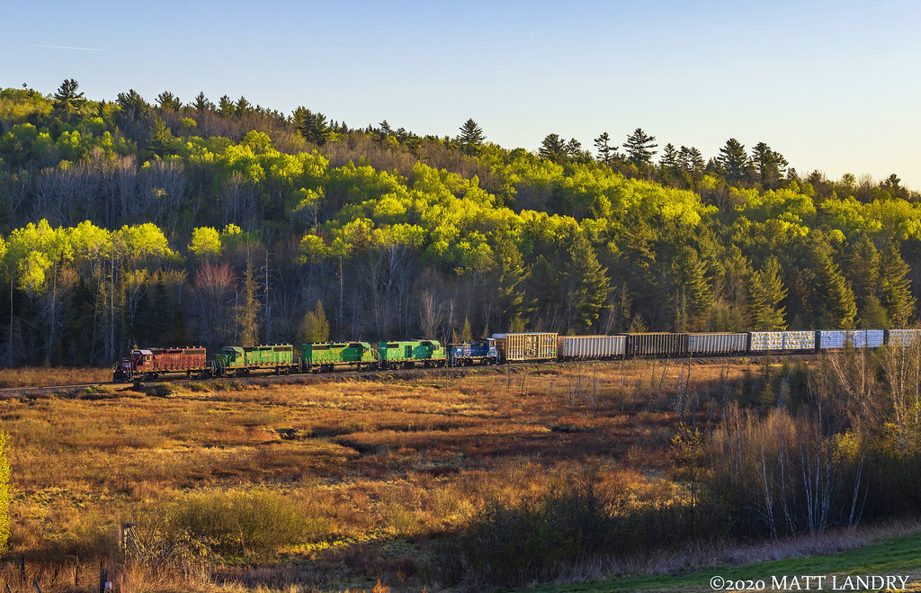 With the sun peeking over the hillside, train 907 is westbound, with a 5-pack of power at Clarendon, New Brunswick near sunrise.
