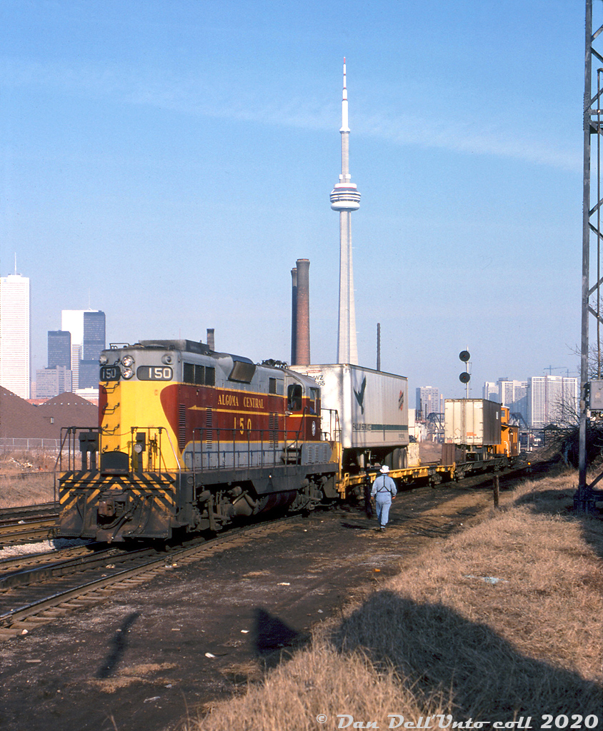 More leased power on CP, this time in the form of Algoma Central GP7's! In late 1978 / early 1979, CP leased a pair of GP7's from Algoma Central, units 150 and 154. Photos show they saw service mainly in the Toronto area, including working locals and transfers around Parkdale Yard, and operating on the Cobourg Turn out of Agincourt. CP got their hands on them sometime during (or before?) December 1978, and they had gone off-lease at the end of March 1979. CP would later come knocking again in the 80's and lease some of ACR's SD40-2 units.

Here, ACR GP7 150 handles some piggyback traffic (transfer from John Street downtown?) at the south end of CP's Parkdale Yard, by the Strachan Avenue grade crossing. Note the C&NW "Falcon Service" pig on the first flat, and CP caboose 437086 bringing up the rear. One can pick out the usual downtown Toronto skyline features including the TD Centre buildings, CN Tower, Wellington Destructor smokestacks, and in the distance CP's Tecumseh Tower (that controlled movements from CP's Parkdale Yard across CN's Weston Sub to the Simcoe/Wellington freight shed lead. Strachan Avenue was still a similar gritty scene in 2007 (and that old yard lighting tower on the right was still there!), but today it's been radically altered with a giant trench under the road for the Strachan Avenue grade separation.

Keith Hansen photo, Dan Dell'Unto collection slide.