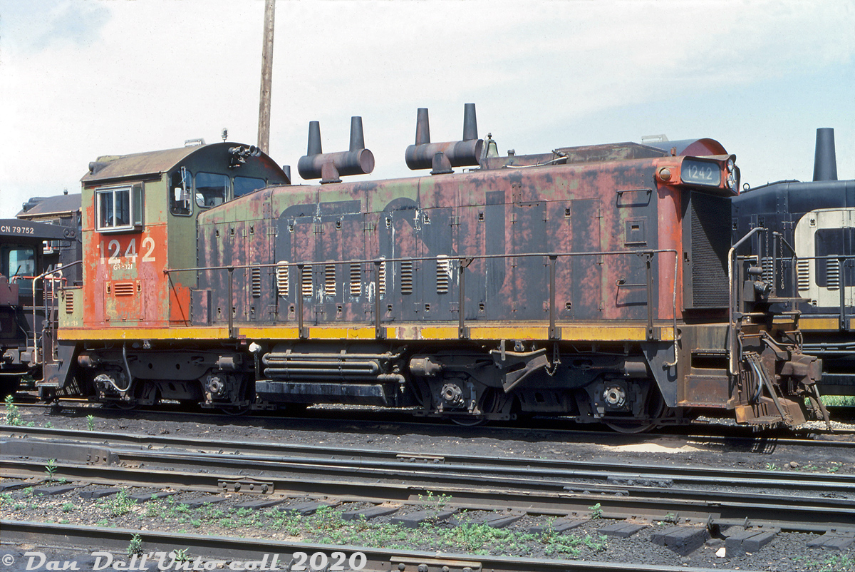 CN SW1200RS 1242 is looking a little bit rough late in its career on CN, and is slowly reverting from the black and red noodle scheme into its original as-built factory green paint, showing through under the faded black and primer red paint. 1242 would be retired the next year in 1991, and resold to Independent Locomotive Services (ILSX). Over the last few recent years, it has worked as an industrial switcher at Strata Corporation in Trail MN, as BGSX 1242.

Ori Siegel photo, Dan Dell'Unto collection slide.