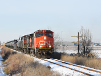 CN 439 trundles along the jointed rail of the Pelton spur past wireless code line poles and the property line for Windsor Airport. 